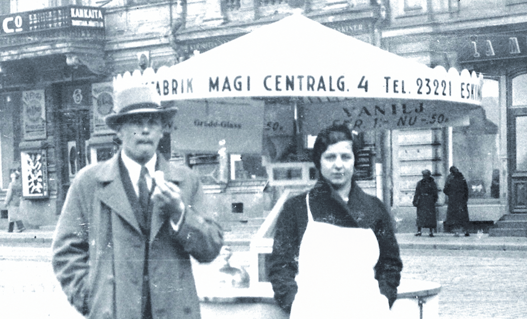 1900-luvun alun herrasvaatteisiin pukeutunut mies nauttii jäätelöä vanhassa kuvassa